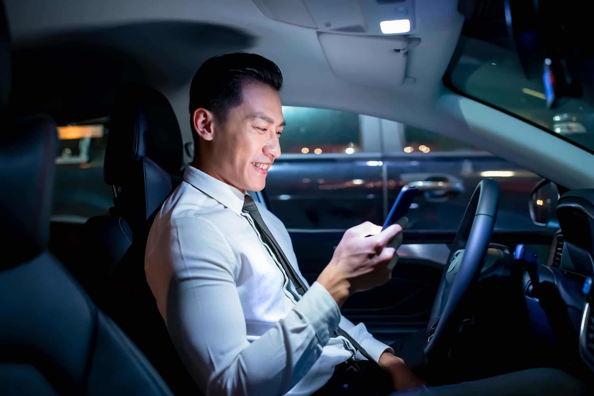 asian businessman use smartphone in the car